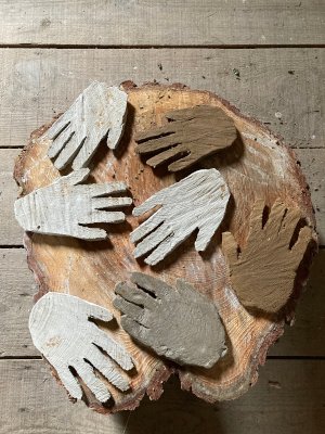 Clay hands on pine log in barn attic